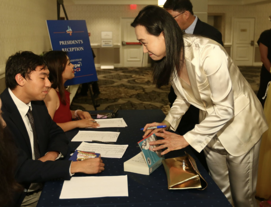 Min Jin Lee signs a book for Gordon Shi at AAJA23